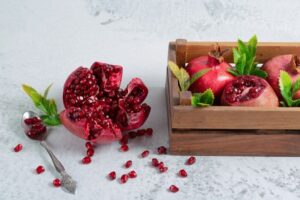 fresh-sliced-pomegranate-grey-surface-with-fruit-bow_114579-82965