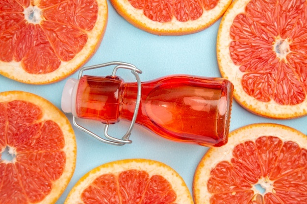 top-close-view-fresh-grapefruits-fruit-slices-blue-background_140725-124303