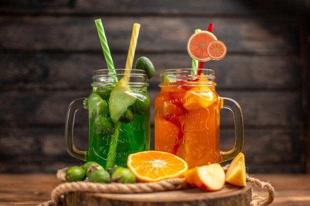 top-view-fresh-delicious-fruit-juices-served-with-apple-feijoas-oranges-wooden-cutting-board_140725-94735